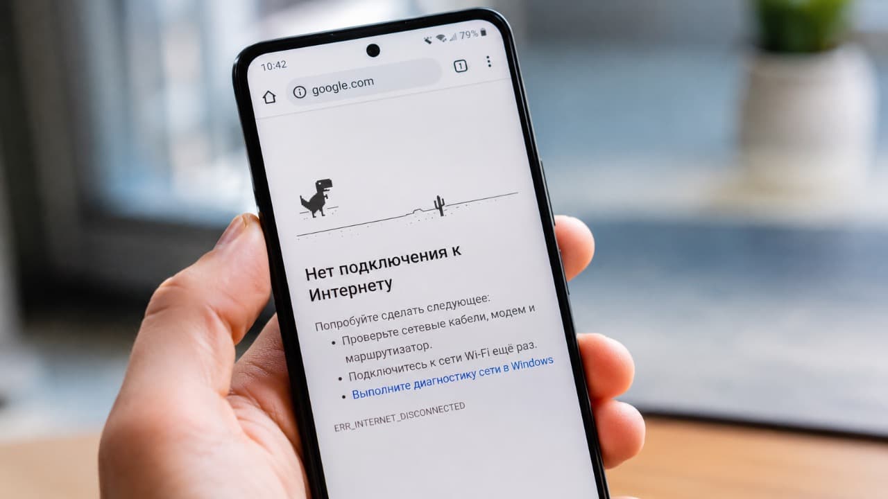 Телефон на Андроид в руке с неработающим интернетом.